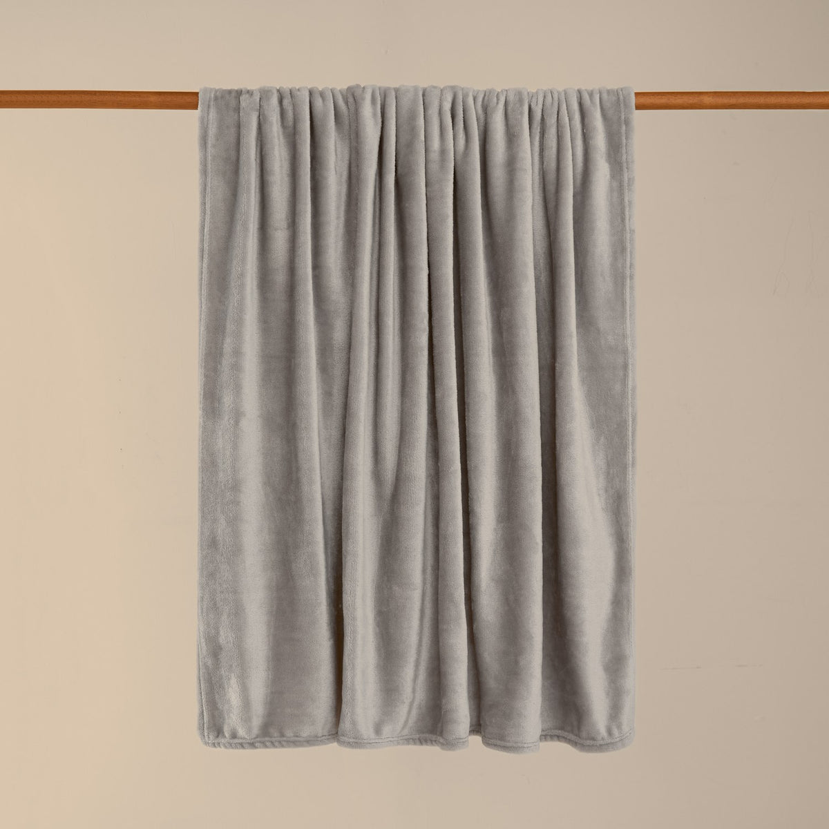 Harrow Plain Polyester Throw in grey flannel fleece, draped over a wooden rail against a plain neutral background.