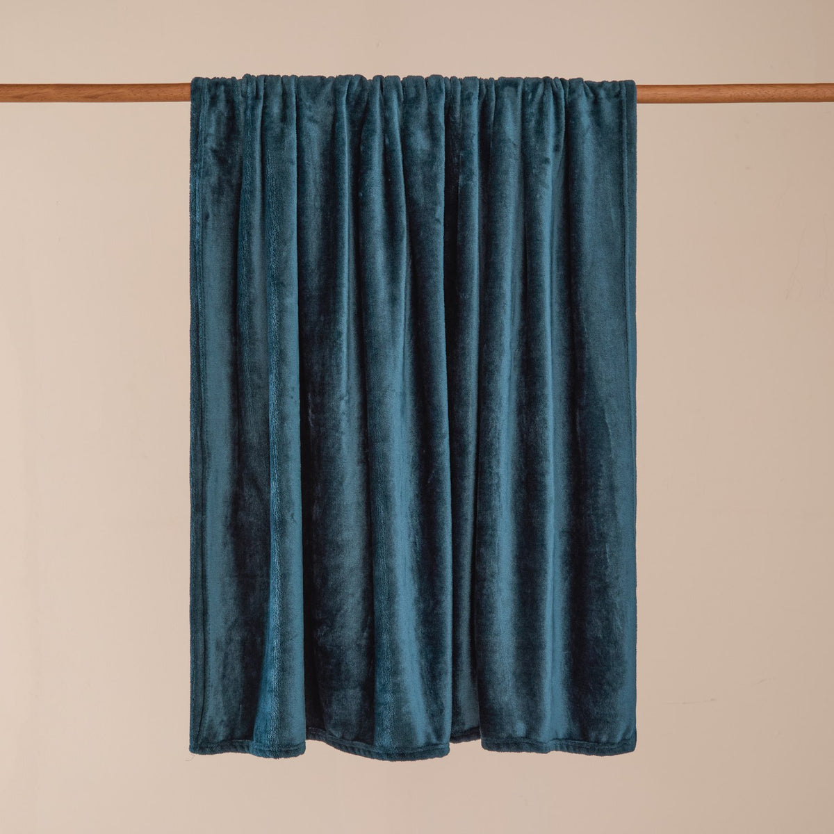 Harrow Plain Polyester Throw in midnight blue, a plain flannel fleece throw draped over a wooden rail against a neutral background, showing its dense pile and soft folds.