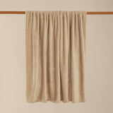 Harrow Plain Polyester Throw in natural cream flannel fleece, draped over a wooden rail against a plain neutral background, showing its smooth, even pile.