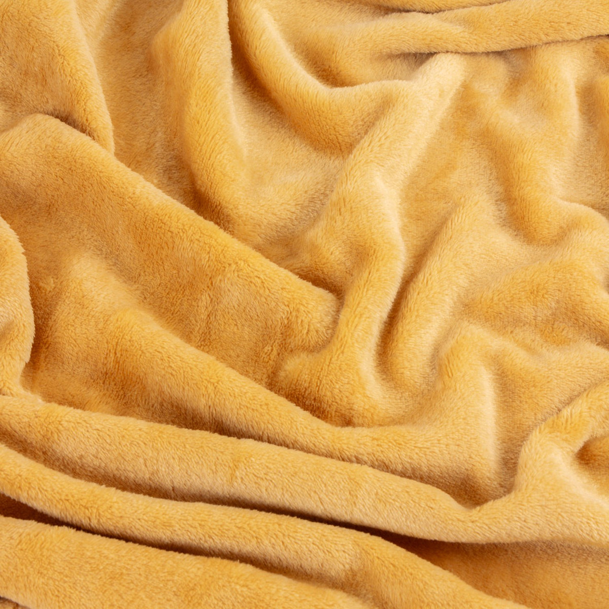 Close-up of the Harrow Plain Polyester Throw in ochre, showing its soft, brushed flannel fleece texture with gentle folds.