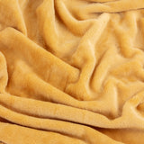 Close-up of the Harrow Plain Polyester Throw in ochre, showing its soft, brushed flannel fleece texture with gentle folds.