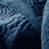 Close-up of the Haze Velvet Cotton Throw in Bluebell, showing quilted cotton velvet with irregular hand-stitched texture in deep blue.