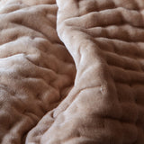 Close-up of the Haze Velvet Cotton Throw in coral-brown, showing hand-quilted velvet texture with soft folds and visible stitching rows.