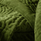 Close-up of the Haze Velvet Cotton Throw in grass green, showing hand-quilted rippling texture and a smoother velvet border edge.