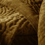 Close-up of the Haze Velvet Cotton Throw in mustard, showing hand-quilted, rippled cotton velvet texture with a folded edge and dense, short pile finish.
