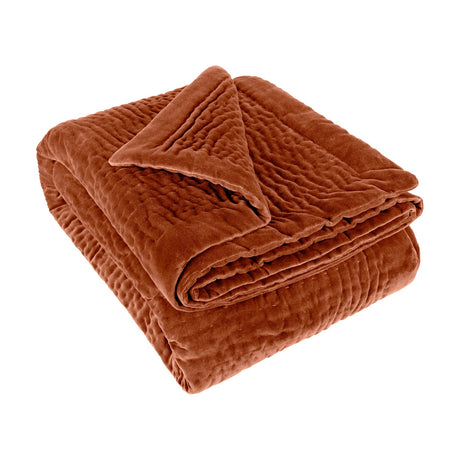 Haze Velvet Cotton Throw in Sunset, a folded rust-orange velvet cotton throw with hand-quilted, rippled texture, shown against a plain white background.