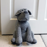 Herringbone Dog Animal Polyester Door Stop in Grey, sitting dog shape with black collar, beaded eyes and darker ears, paws and nose, set against a white door.