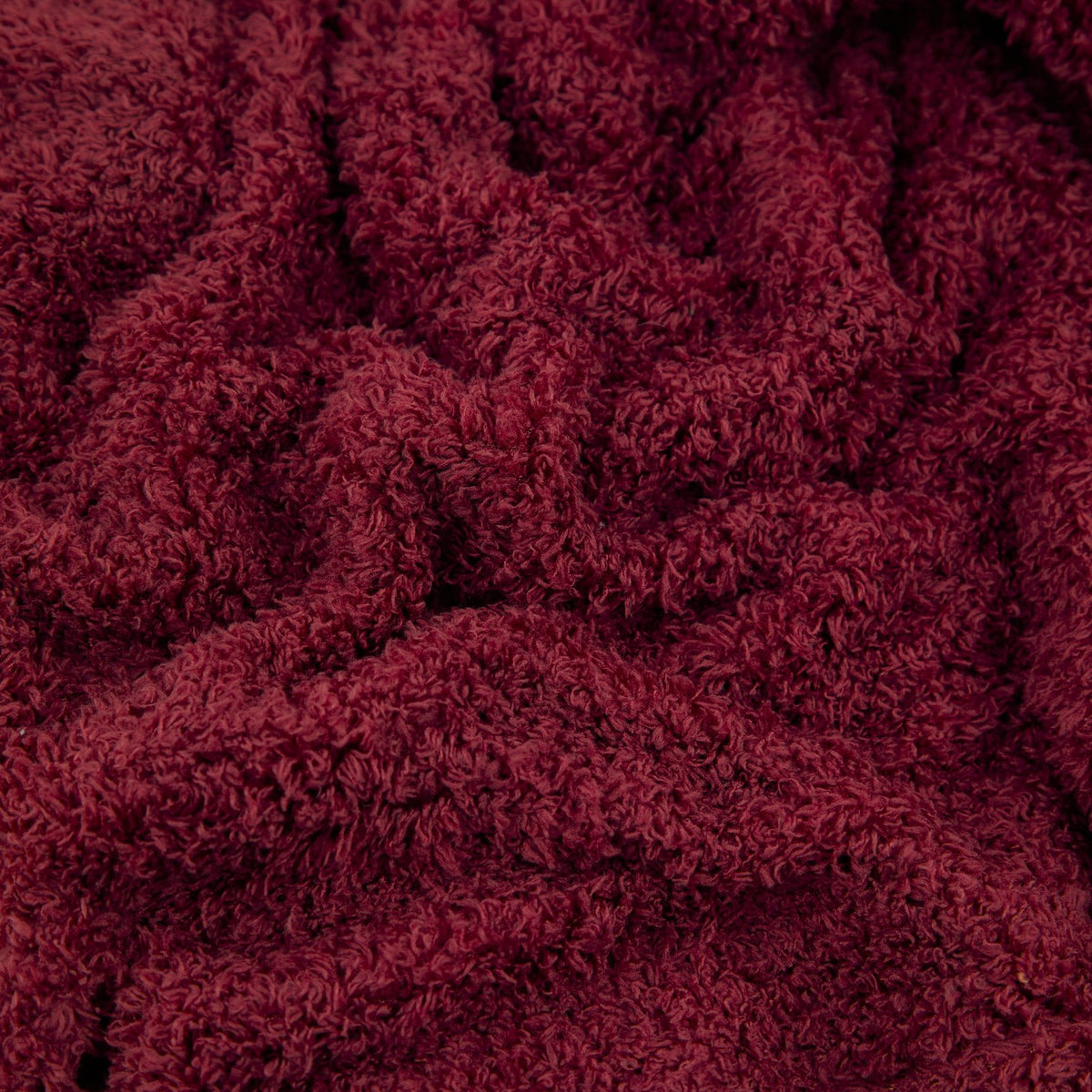 Close-up of the Harlan Borg Sherpa Plain Polyester Throw in burgundy, showing its dense, curly textured pile fabric.