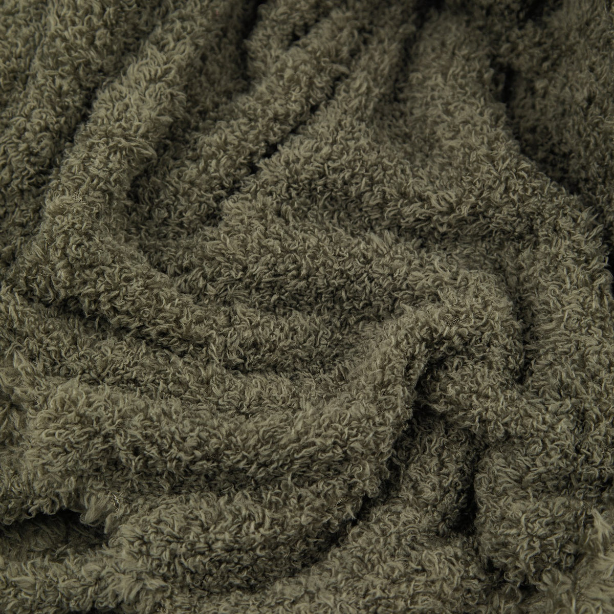 Close-up of the Harlan Borg Sherpa Plain Polyester Throw in olive green, showing its dense, curly-piled fleece texture draped in loose folds.