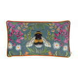 House of Bloom rectangular velvet cushion featuring a central bee design with pink, magenta, white and orange florals and green foliage on blue-grey, orange piped edge, white background.