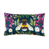 Rectangular navy polyester scatter cushion with a hand-painted bumble bee at its centre, surrounded by pink honeysuckle, white daisies and green foliage, shown on a plain white background.