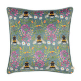 House of Bloom Floral Velvet Cushion, square with piped edge, blue-grey velvet printed with bumble bees, pink and white florals, and green foliage, shown on a white background.