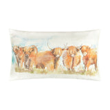 Rectangular linen-cotton cushion in Russet featuring a hand-painted watercolour row of highland cattle in russet and amber tones against a pale blue and cream sky, shown on a plain white background.