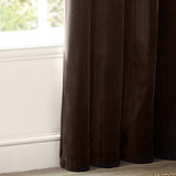 Heavy chenille velvet eyelet curtains in deep brown, showing dense pile fabric and lined panel folds pooling near a window with white skirting board.
