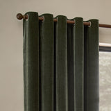 Heavy Chenille Velvet Fully Lined Eyelet Curtains in lichen green, hung on a wooden pole with metal eyelets, forming rounded folds against a neutral wall.