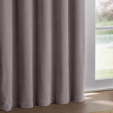 Heavy chenille velvet eyelet curtains in mauve, fully lined with soft folds, shown hanging beside a window in a bright room with wooden flooring.