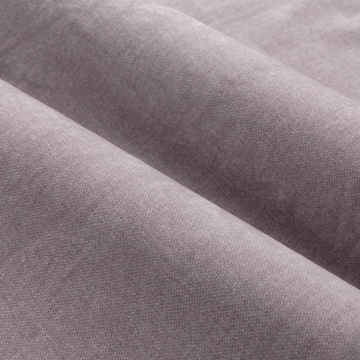 Close-up of heavy chenille velvet fabric from the eyelet curtains in soft, dusty mauve, showing the soft, matt pile weave texture in a draped fold.