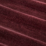 Close-up of heavy chenille velvet pencil pleat curtain fabric in deep beetroot red, showing the woven pile texture and soft folds.