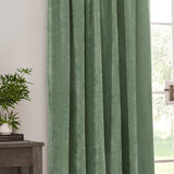 Heavy Chenille Plain Velvet Pencil Pleat Curtains in eucalyptus green, shown hanging in pencil-pleat folds beside a window in a living room setting.