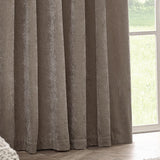 Heavy Chenille Plain Velvet Pencil Pleat Curtains in greige, shown in soft folds beside a window overlooking greenery, highlighting the textured chenille pile.