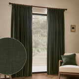 Lichen green heavy chenille velvet pencil pleat curtains hanging on a wooden pole in a living room, with a fabric texture close-up and matching cushion shown.