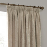Heavy Chenille Plain Velvet Pencil Pleat Curtains in natural beige, hung on a wooden pole with pencil pleat heading, shown against a light grey wall.