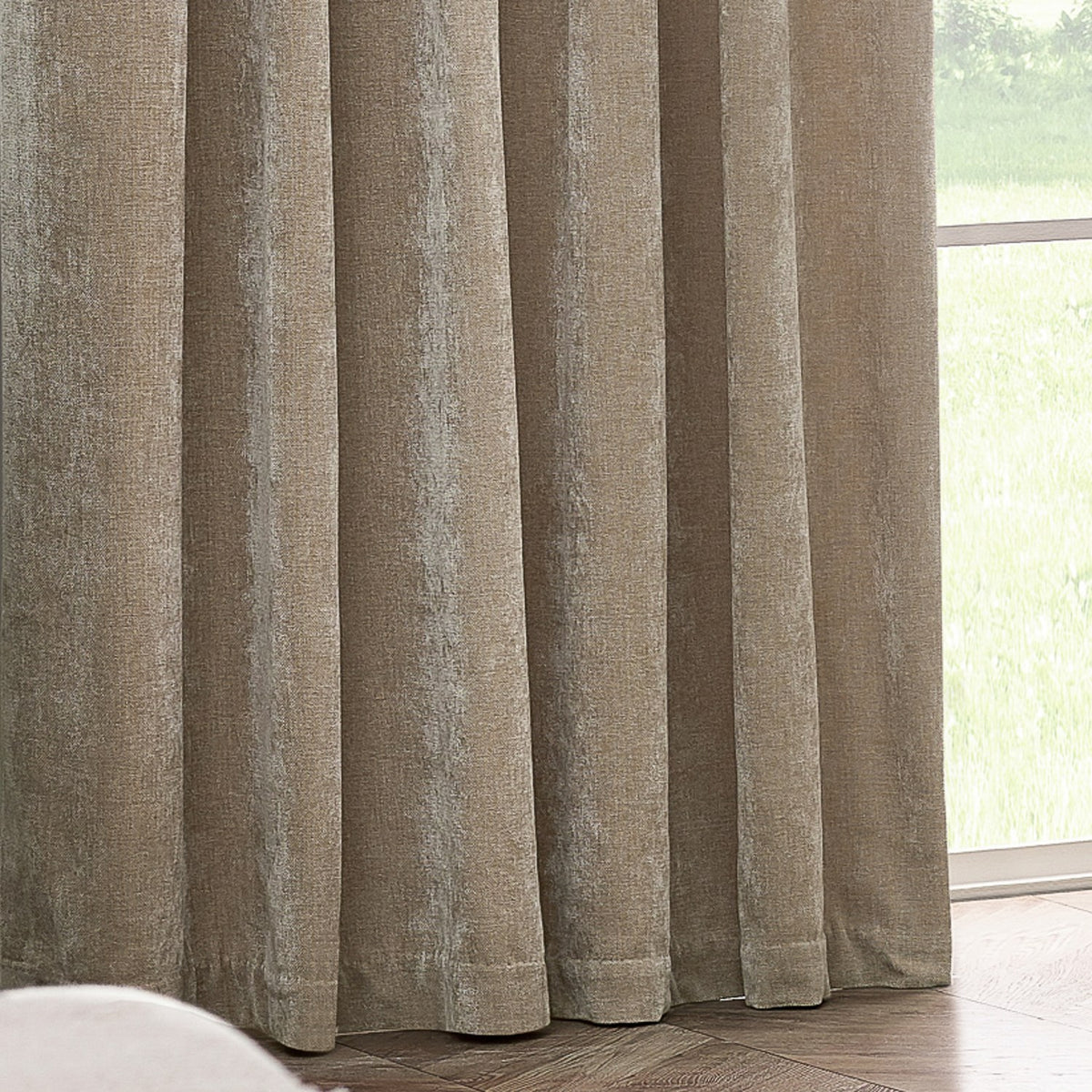 Pencil pleat curtains in natural beige heavy chenille velvet, shown floor-length with soft folds beside a window overlooking a garden.