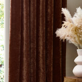 Heavy Chenille Plain Velvet Pencil Pleat Curtains in Nutmeg, shown in soft folds beside a window, styled in a living room with a textured vase and dried pampas grass.