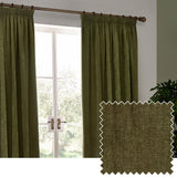 Olive green heavy chenille velvet pencil pleat curtains hung on a wooden pole beside a French door, with a fabric swatch showing the woven texture.