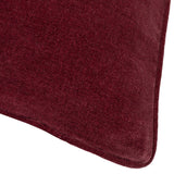 Close-up of a square cushion corner in beetroot red heavy chenille velvet, showing the textured slubbed weave and piped edge detail.