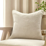 Heavy Chenille Velvet Linen Cushion in beige, square with piped edge trim, styled on a woven cane chair with a linen curtain backdrop.