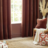 Nutmeg Heavy Chenille Velvet Cushion in reddish-brown on a wooden chair, styled with a striped throw and a patterned red cushion in a living room setting.