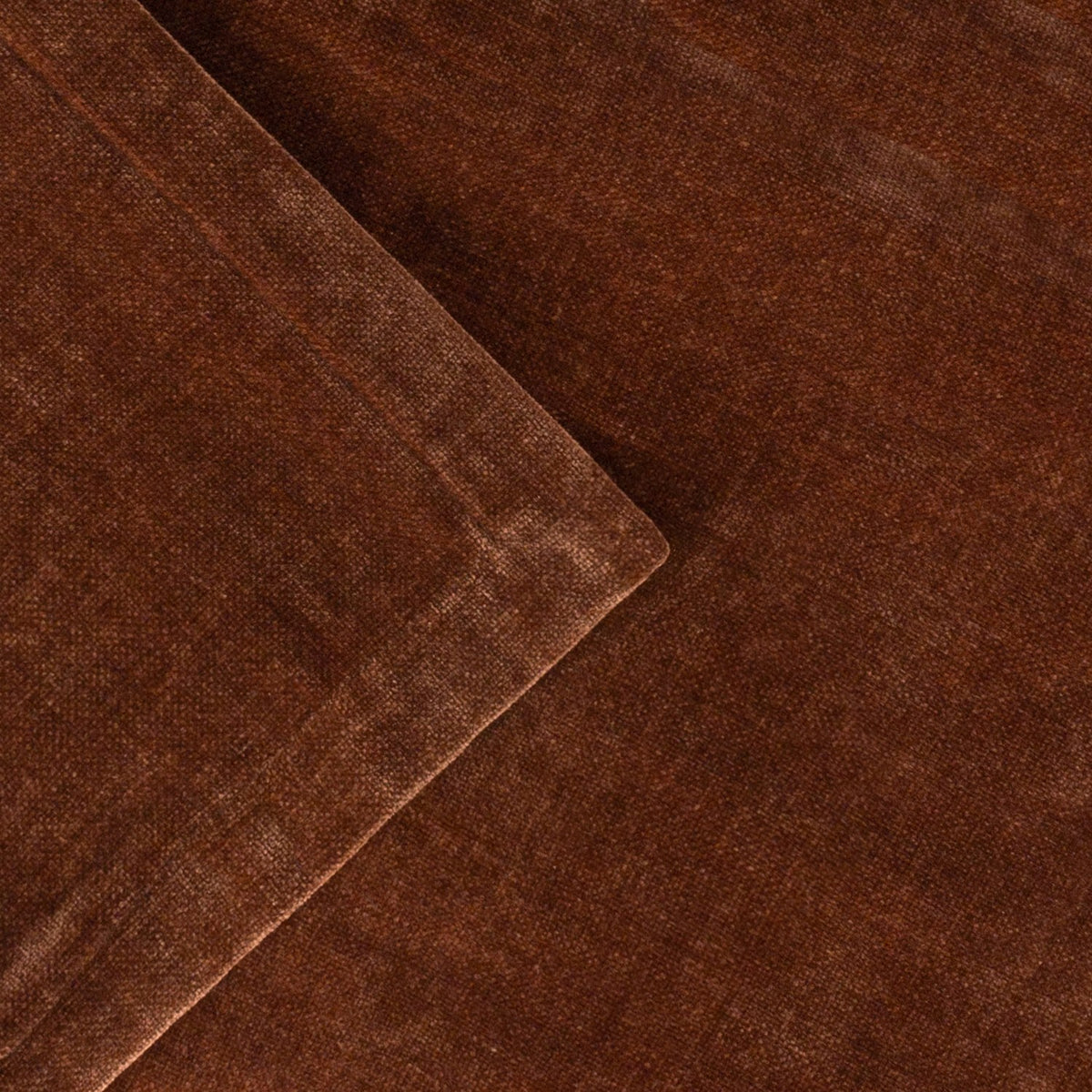 Close-up of the Heavy Chenille Eyelet Velvet Throw in nutmeg brown, showing folded fabric with a soft tufted pile and subtle sheen variation across the surface.