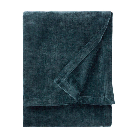 Folded navy chenille velvet throw with a soft, dense nap and visible sheen variation across the folds, shown on a plain white background.