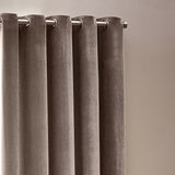 Heavy chenille velvet eyelet curtains in greige, shown hanging in soft folds on a brushed metal rod with visible eyelet grommets against a plain neutral wall.