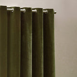 Close-up of olive green heavy chenille velvet eyelet curtains with silver grommets on a metal rod, showing dense pile texture against a light neutral wall.