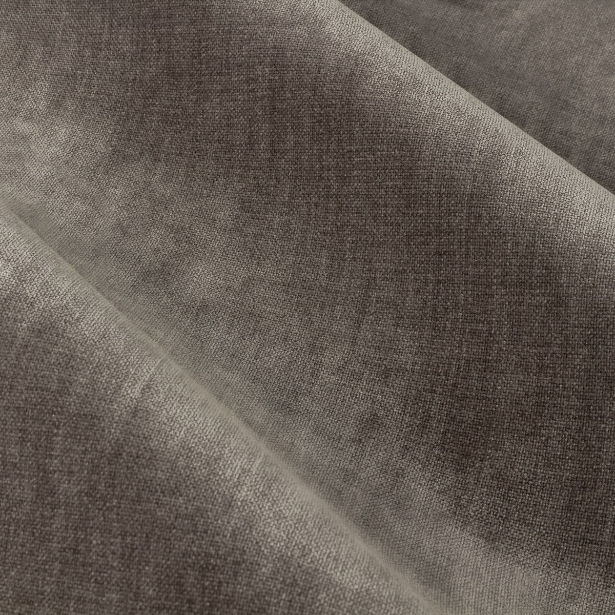 Close-up of heavy chenille velvet pencil pleat curtain fabric in greige, showing its soft pile texture and folded drape.