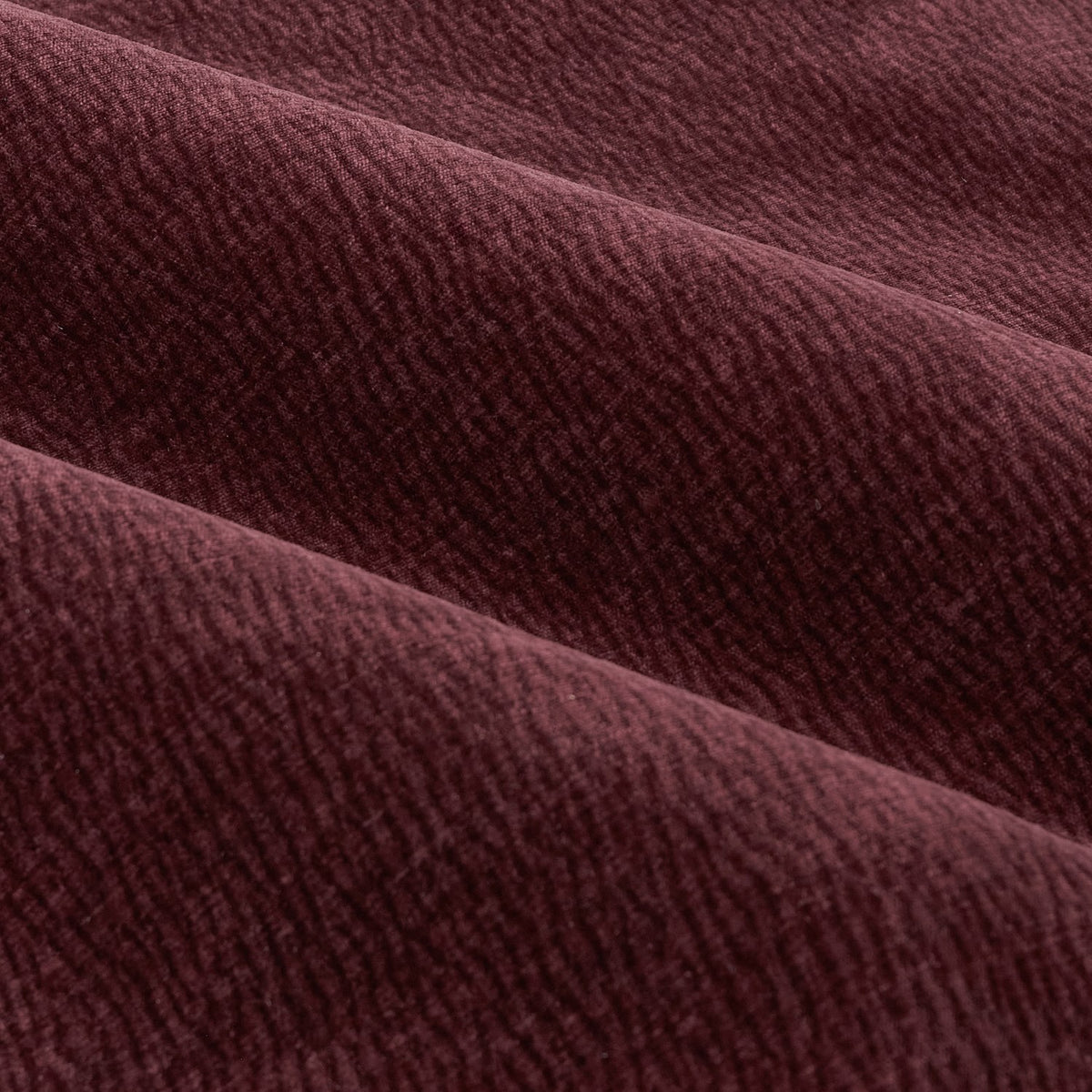 Close-up of Heath eyelet curtains in beetroot washed velvet, showing soft folds and a subtle textured jacquard weave.