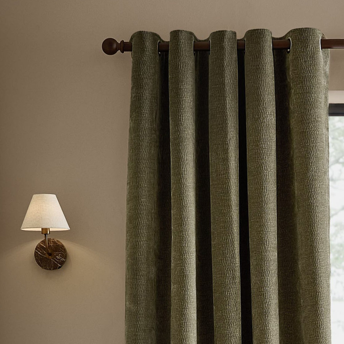Heath Washed Velvet Fully Lined Eyelet Curtains in Eucalyptus, textured green velvet panels on a dark eyelet rod, styled beside a wall-mounted lamp with linen shade.