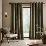 Heath Washed Velvet Fully Lined Eyelet Curtains in eucalyptus green, textured fabric with eyelet header, shown floor-length beside a window in a living room setting.