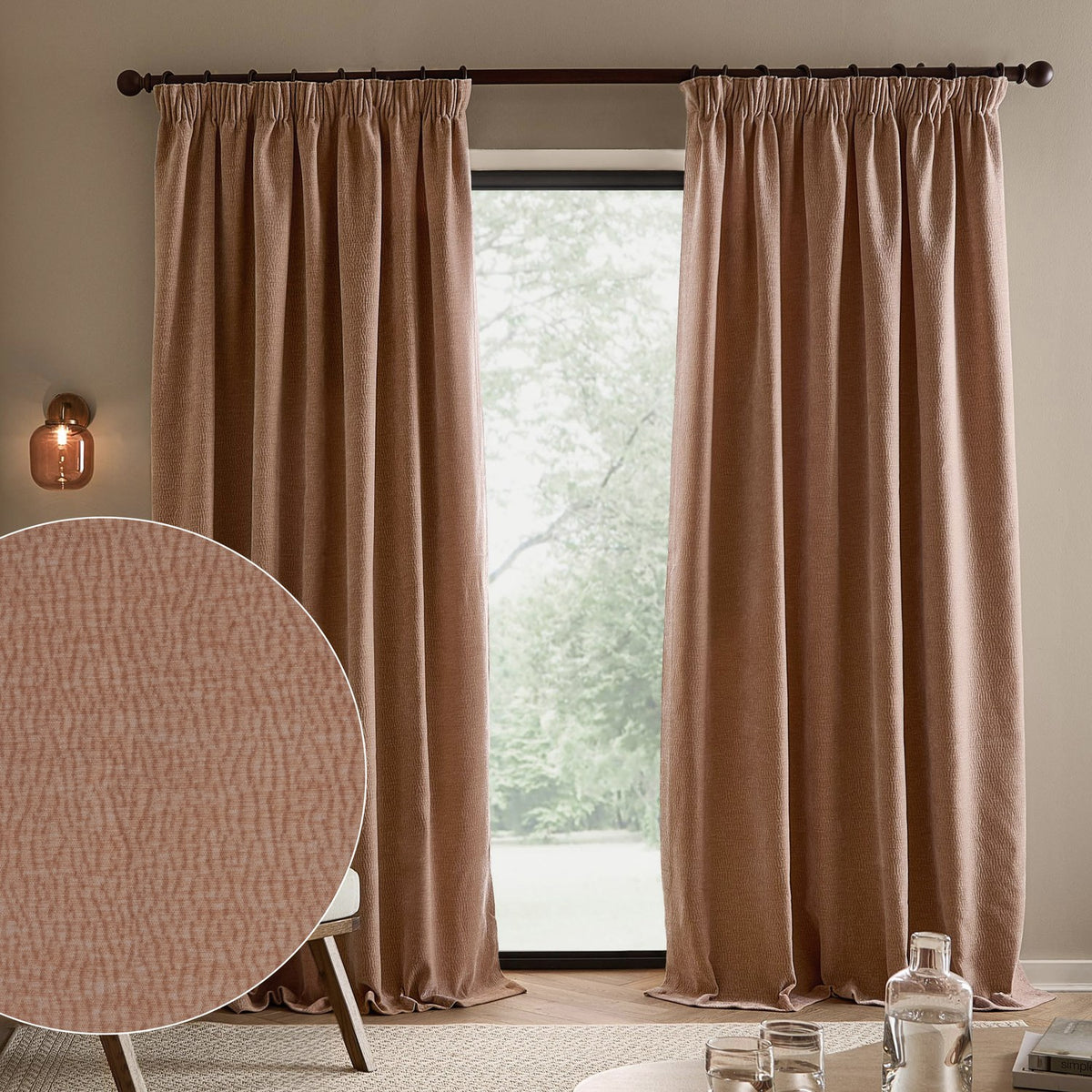 Heath Washed Velvet Pencil Pleat Curtains in Cotta, a pair of terracotta pink jacquard-textured panels on a dark pole, shown in a living room beside a window.
