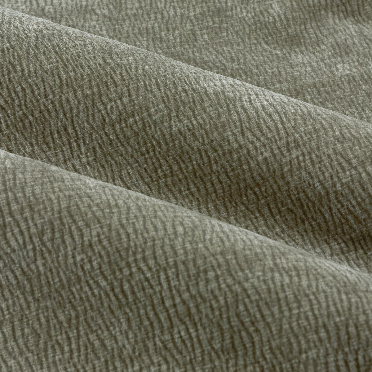 Close-up of Heath Pencil Pleat Curtains in Eucalyptus, showing draped enzyme-washed velvet fabric with a subtle jacquard weave texture in soft olive green.