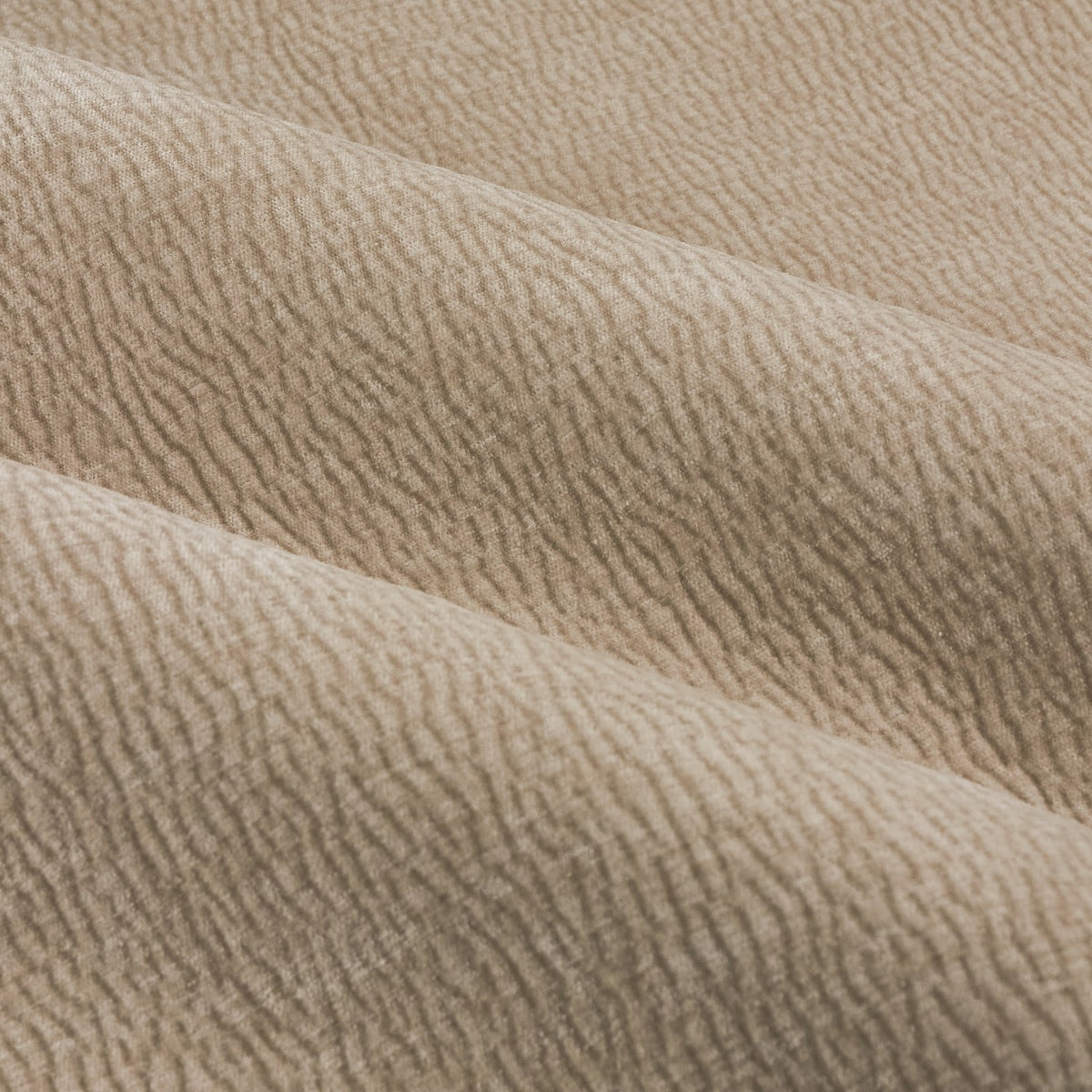 Close-up of Heath Washed Velvet Pencil Pleat Curtains in beige, showing draped fabric folds with a subtle jacquard textured, crumpled-pile finish.