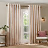 Hebden Cotton Fully Lined Eyelet Curtains in Blush, showing pink and cream striped panels with metal eyelet headers hung on a wooden pole in a living room setting.