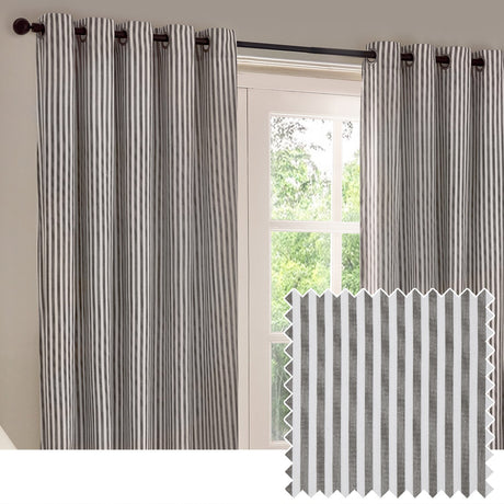 Hebden Cotton Lined Eyelet Curtains in grey vertical stripe hang on a black pole beside a window, with a matching striped fabric swatch shown inset.