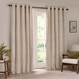 Hebden Cotton Lined Eyelet Curtains in natural beige stripe, hung on a bronze pole either side of a French door in a living room.