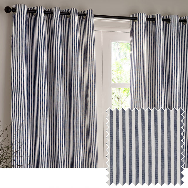 Hebden Cotton Lined Eyelet Curtains in navy and white vertical stripe, hung on a black eyelet rod beside a glass door, with a folded fabric swatch shown below.