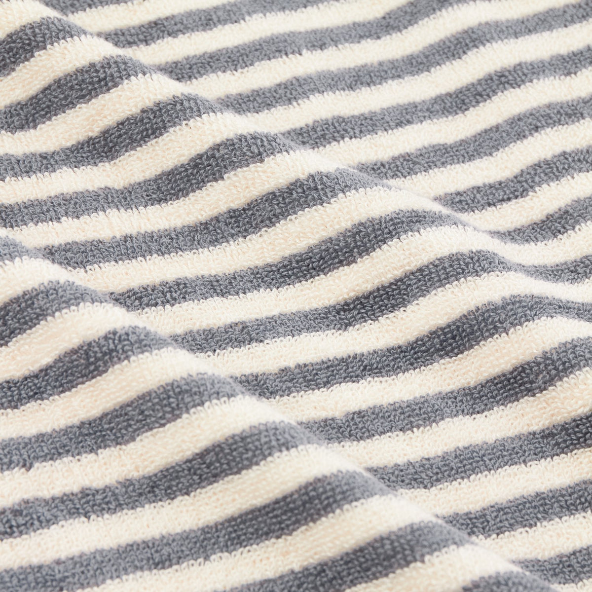 Close-up of the Hebden Striped Cotton Bath Mat in grey, showing textured terry cotton loops in alternating grey and off-white horizontal stripes.