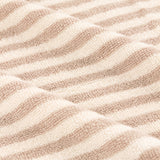 Close-up of the Hebden Striped Cotton Bath Mat showing textured cotton terry with soft beige and off-white horizontal stripes.