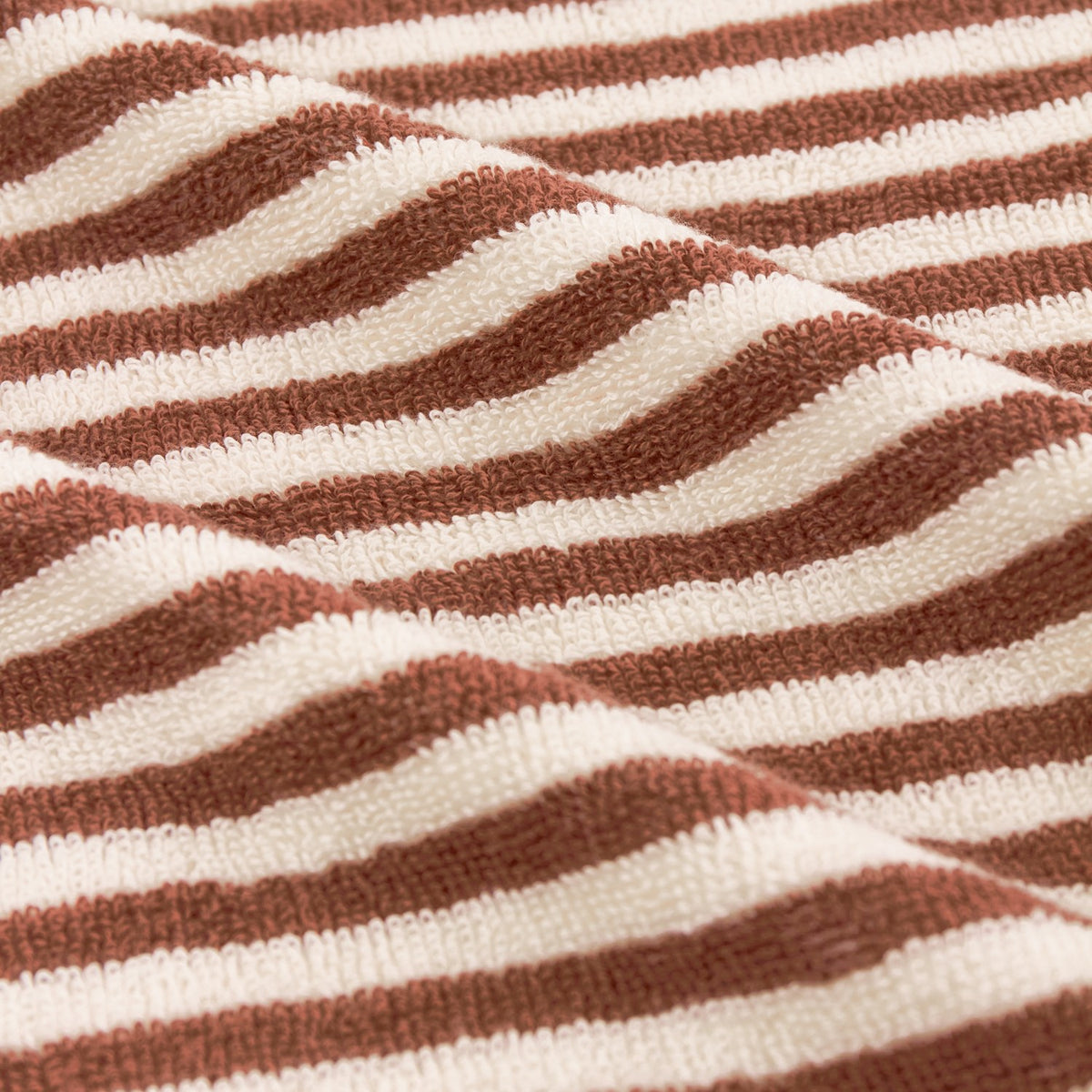 Close-up of the Hebden Striped Cotton Bath Mat in pecan brown and cream, showing woven cotton terry texture with vertical stripes.